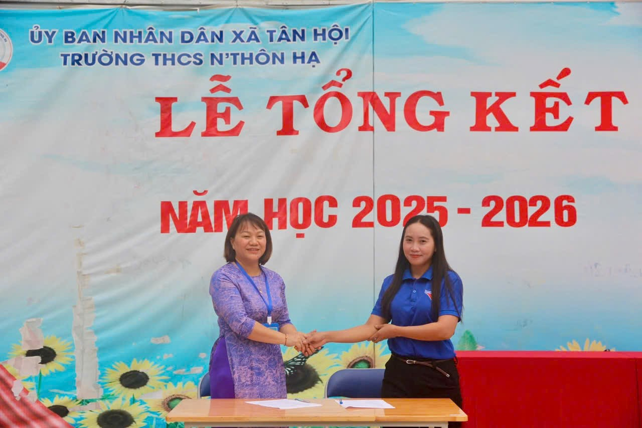 ''''''Two women shaking hands in front of a banner

AI-generated content may be incorrect.''''''
